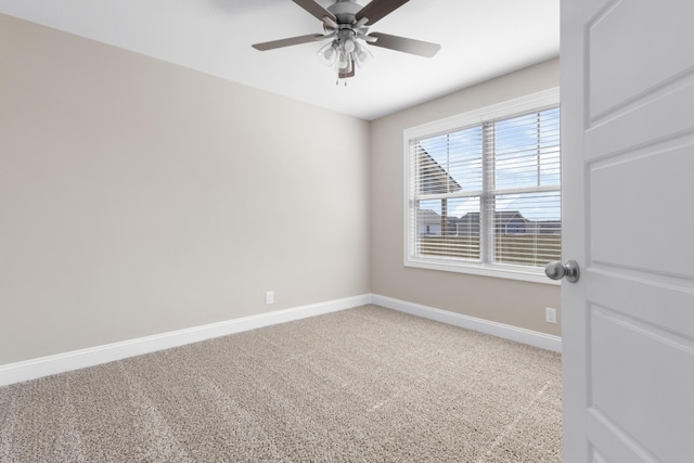 carpeted empty room featuring ceiling fan and baseboards