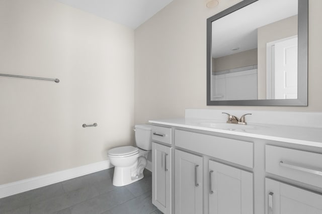 bathroom with baseboards, vanity, toilet, and tile patterned floors