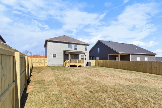 back of property with a fenced backyard, crawl space, a yard, a wooden deck, and central AC