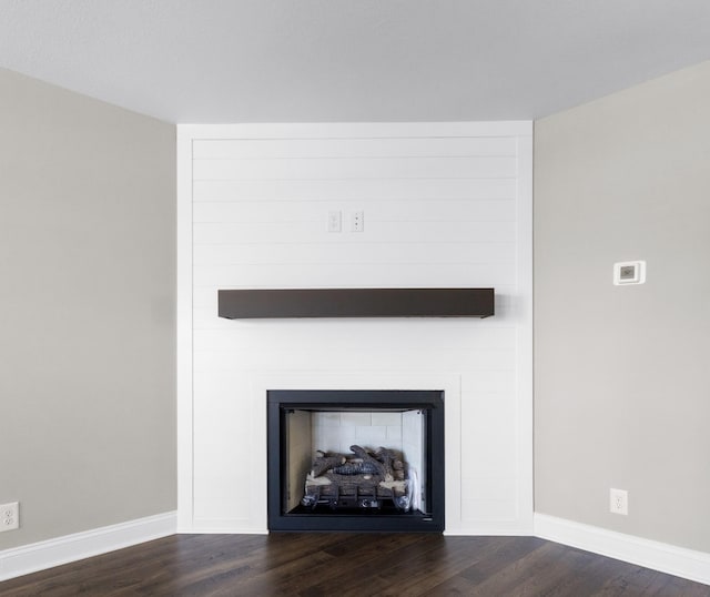 interior details with a fireplace, wood finished floors, and baseboards