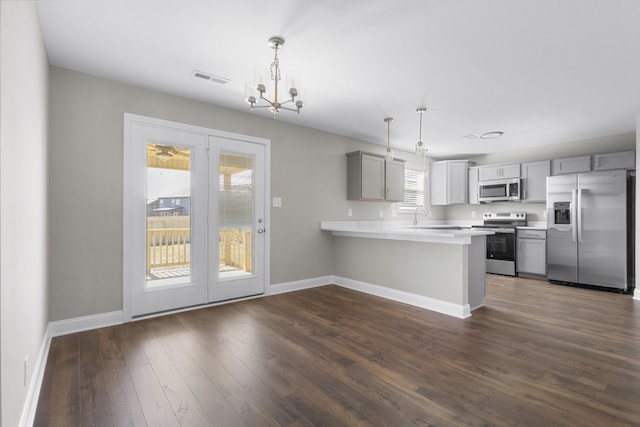 kitchen with gray cabinetry, a peninsula, dark wood-style flooring, visible vents, and appliances with stainless steel finishes