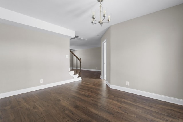 unfurnished room featuring an inviting chandelier, stairs, baseboards, and dark wood finished floors