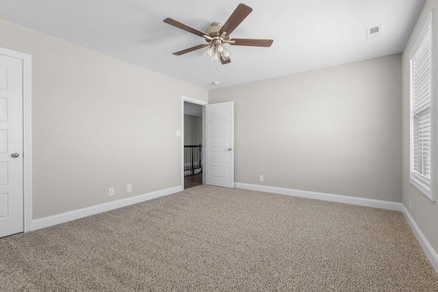 unfurnished bedroom featuring carpet, visible vents, baseboards, and ceiling fan