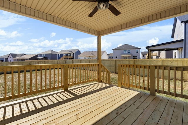 wooden terrace with a fenced backyard, a residential view, and a ceiling fan