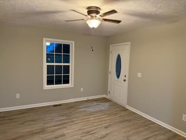 foyer with hardwood / wood-style floors, a textured ceiling, and ceiling fan