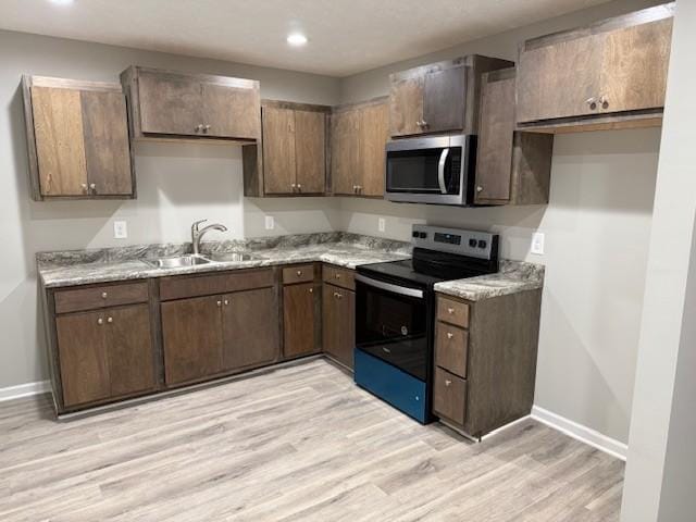 kitchen with sink, range with electric stovetop, light hardwood / wood-style flooring, and dark brown cabinets