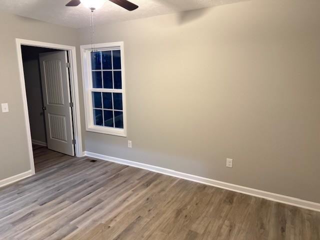 unfurnished room featuring hardwood / wood-style floors and ceiling fan