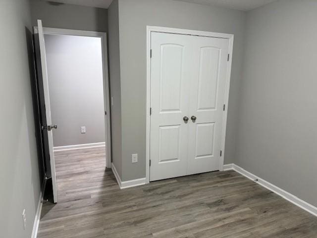 unfurnished bedroom featuring hardwood / wood-style flooring and a closet