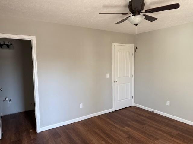 empty room featuring a textured ceiling, wood finished floors, and baseboards