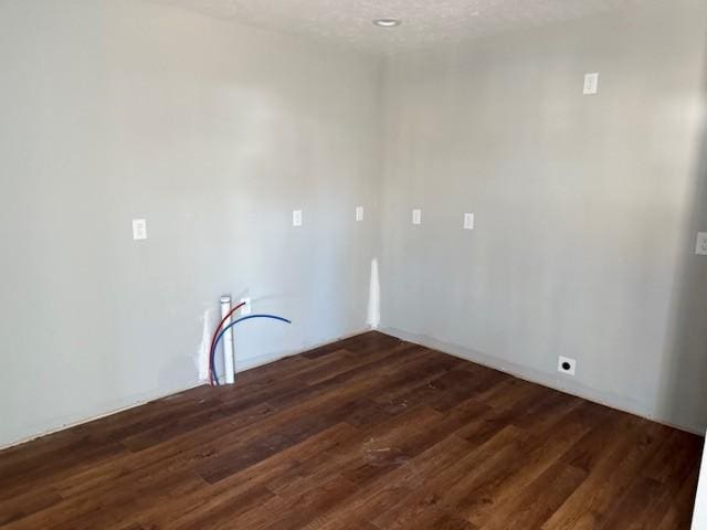 washroom with dark wood-type flooring and a textured ceiling