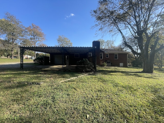 back of property with a carport and a lawn