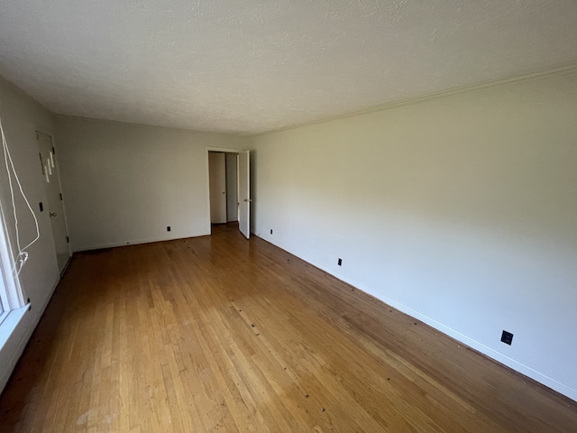 spare room featuring a textured ceiling and light wood-type flooring