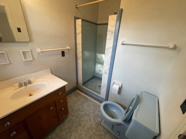 bathroom featuring vanity, toilet, and tiled shower