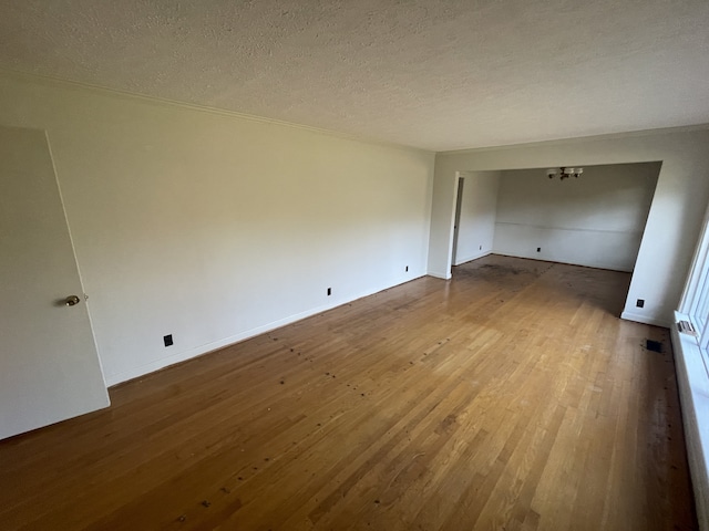 empty room with hardwood / wood-style floors and a textured ceiling