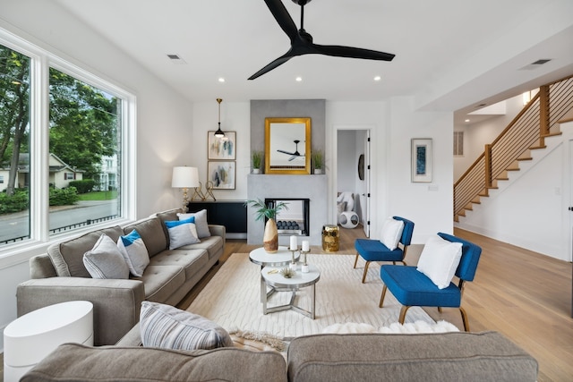 living room with light hardwood / wood-style floors and ceiling fan