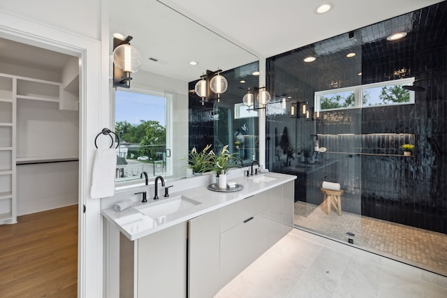 bathroom with vanity, wood-type flooring, and tiled shower