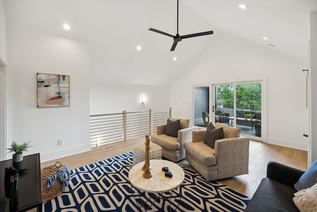 living room featuring light hardwood / wood-style floors, high vaulted ceiling, and ceiling fan