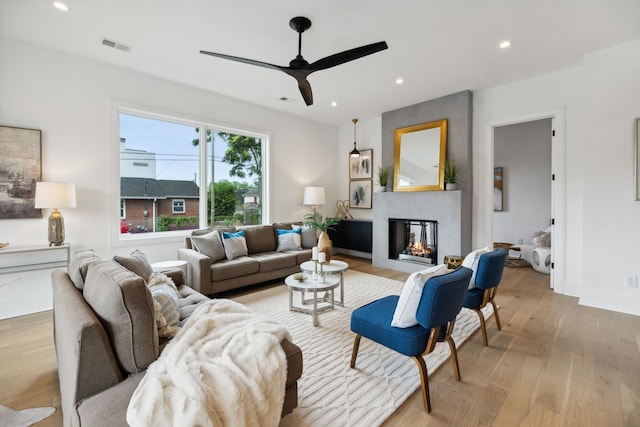 living room with light wood-type flooring and ceiling fan