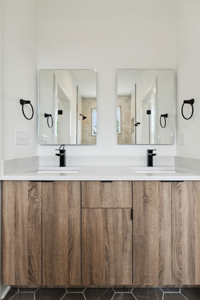 bathroom with vanity, tile patterned flooring, and tiled shower