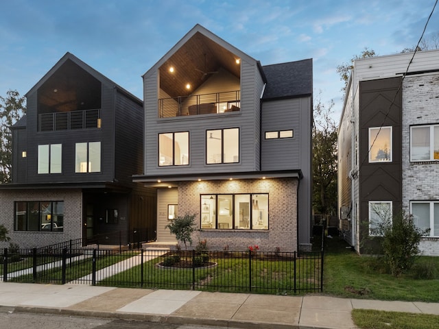 view of front of property with a yard and a balcony