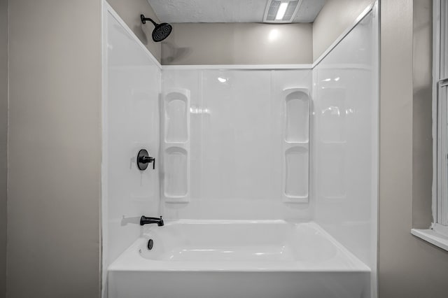 bathroom featuring a textured ceiling and shower / washtub combination