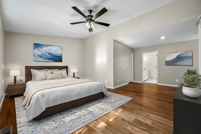 bedroom featuring ceiling fan, hardwood / wood-style flooring, and washer / clothes dryer