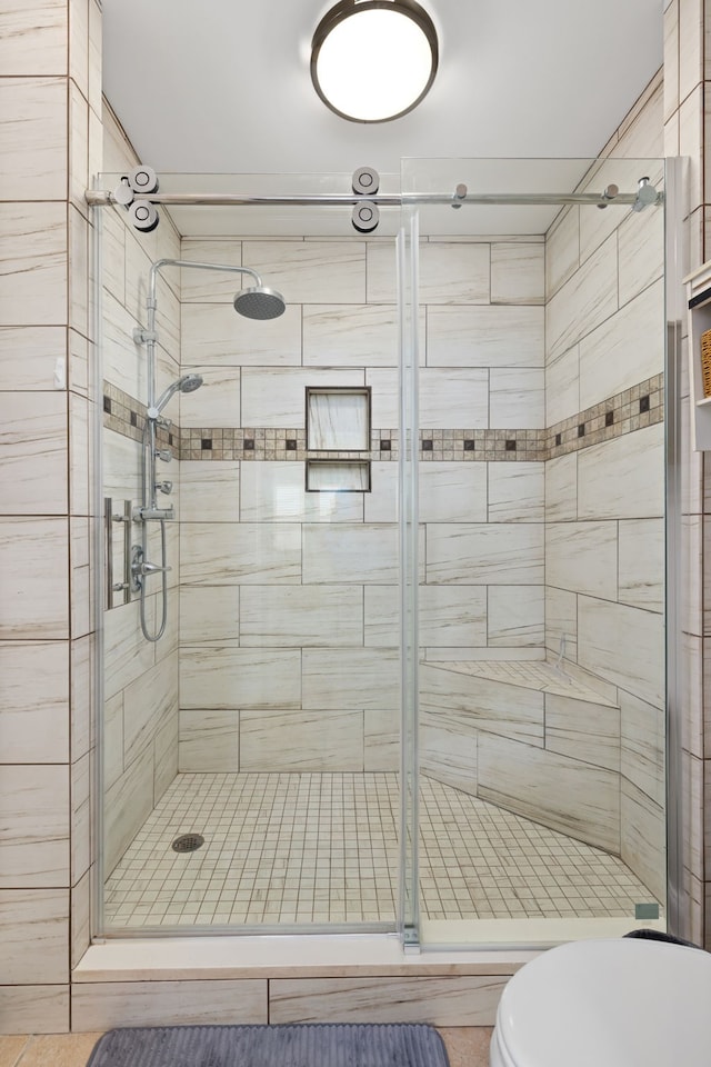 bathroom with toilet and an enclosed shower