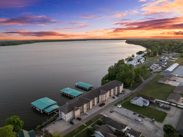 aerial view at dusk featuring a water view