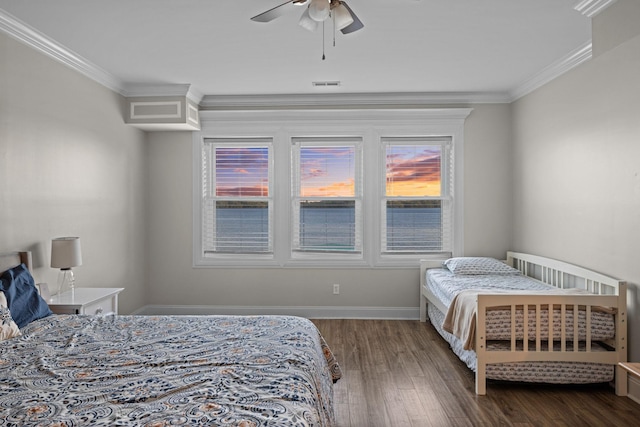 bedroom featuring baseboards, visible vents, dark wood-style flooring, and crown molding