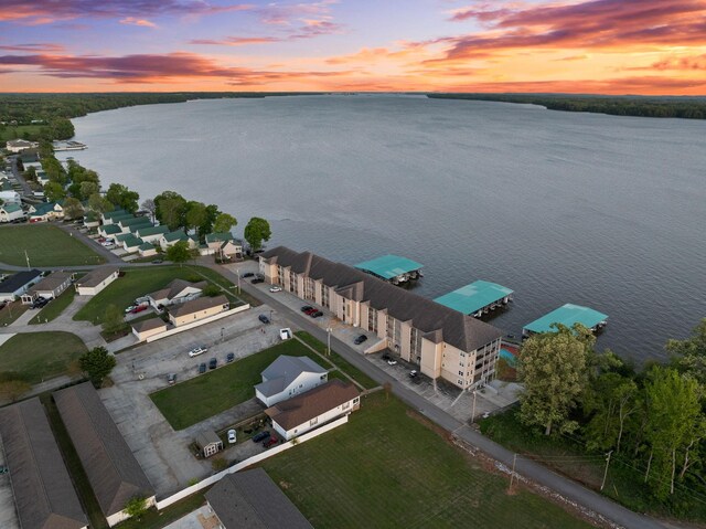 aerial view at dusk featuring a water view