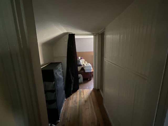 hall featuring lofted ceiling and hardwood / wood-style floors