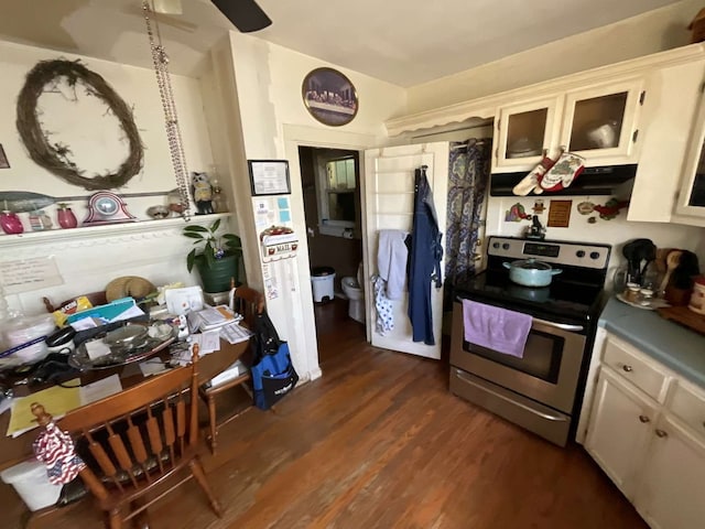 kitchen featuring stainless steel electric stove, extractor fan, white cabinetry, and dark wood-type flooring