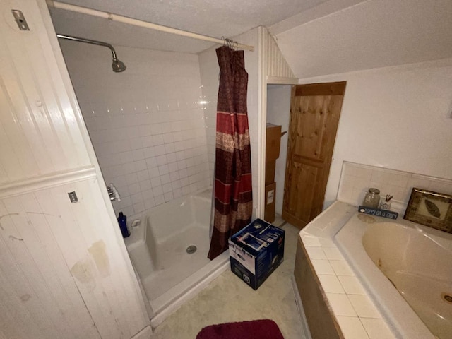 bathroom featuring a textured ceiling and separate shower and tub