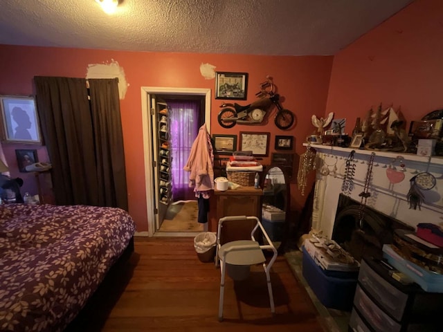 bedroom featuring a textured ceiling and wood-type flooring