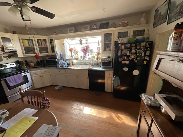 kitchen featuring white cabinets, ceiling fan, hardwood / wood-style flooring, black appliances, and sink