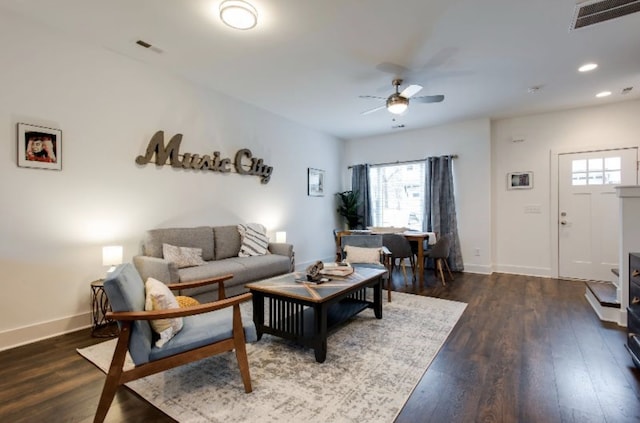 living room with dark wood-type flooring and ceiling fan