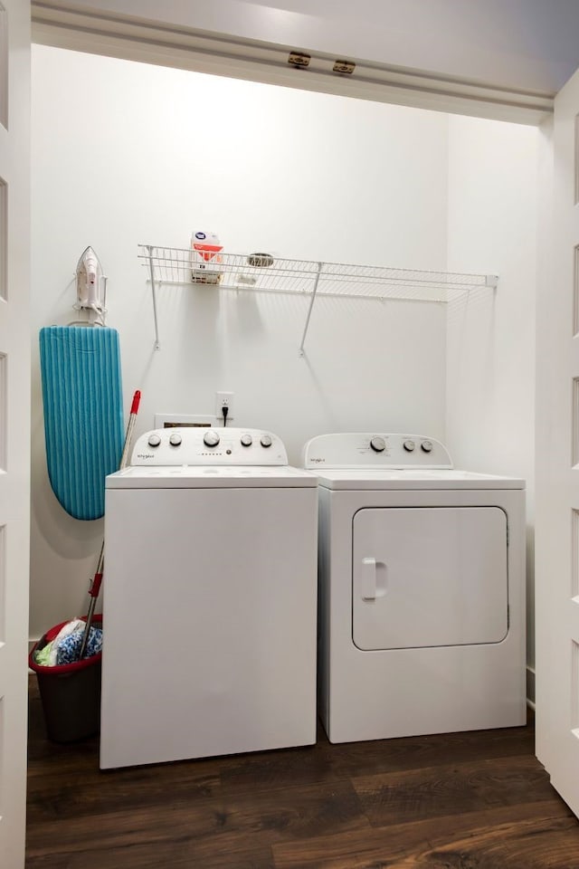 clothes washing area with independent washer and dryer and dark hardwood / wood-style flooring