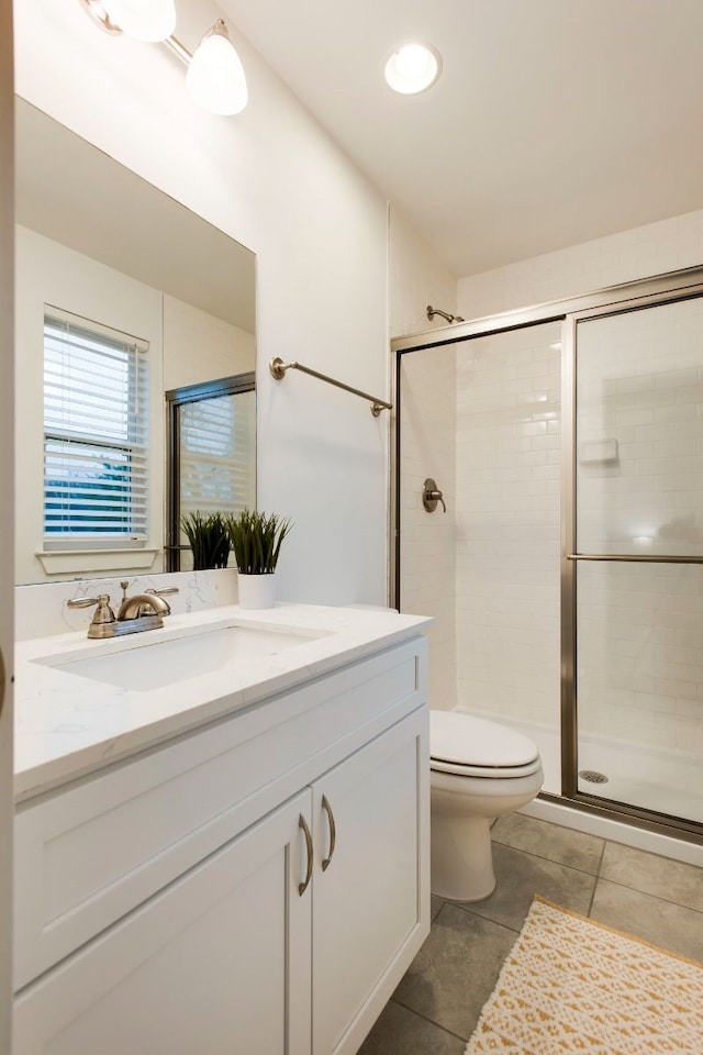 bathroom with vanity, tile patterned flooring, toilet, and an enclosed shower