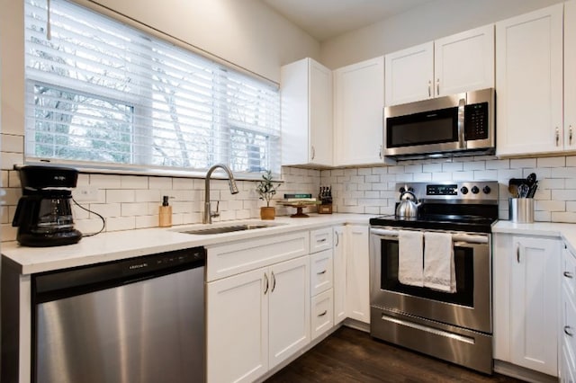 kitchen featuring sink, white cabinetry, stainless steel appliances, and backsplash