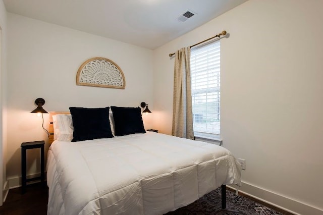 bedroom with dark hardwood / wood-style flooring