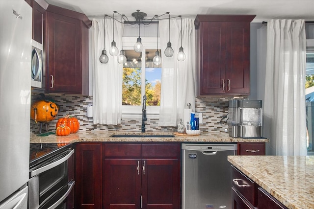 kitchen featuring light stone countertops, sink, appliances with stainless steel finishes, and decorative backsplash