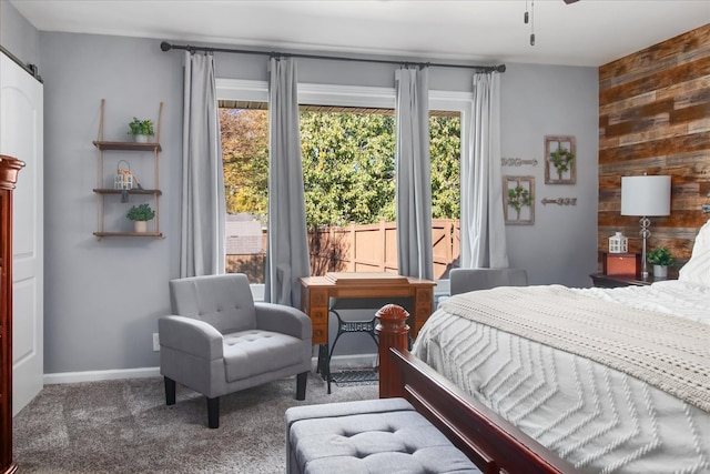 carpeted bedroom featuring wood walls and a barn door