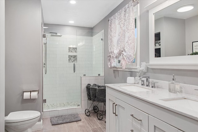 bathroom with vanity, toilet, wood-type flooring, and an enclosed shower