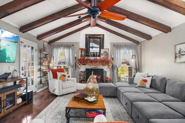 living room featuring dark hardwood / wood-style floors, lofted ceiling with beams, a fireplace, and a wealth of natural light