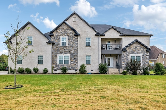 view of front of house featuring a balcony and a front lawn