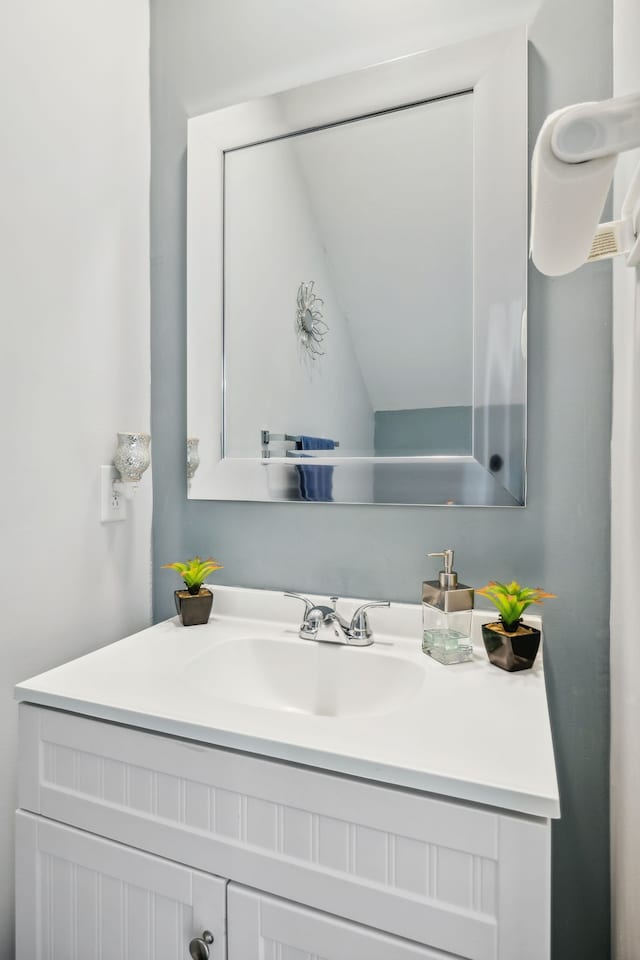 bathroom featuring vanity and lofted ceiling