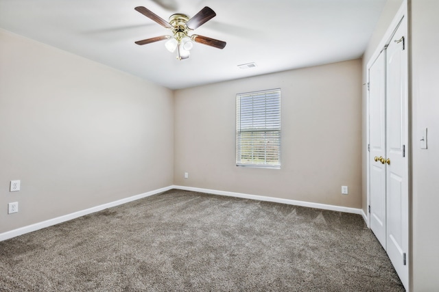 unfurnished bedroom featuring ceiling fan and dark colored carpet