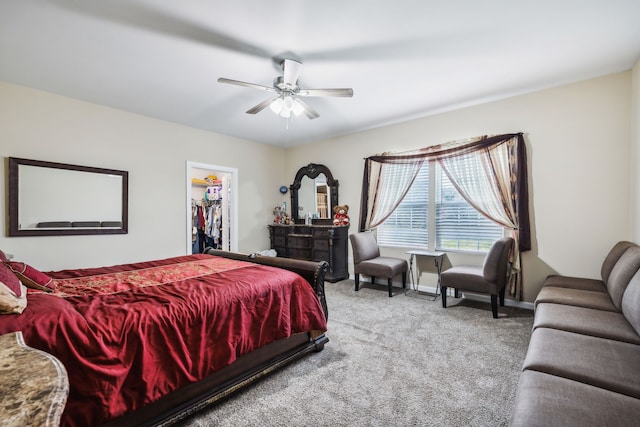 bedroom featuring a walk in closet, a closet, carpet flooring, and ceiling fan