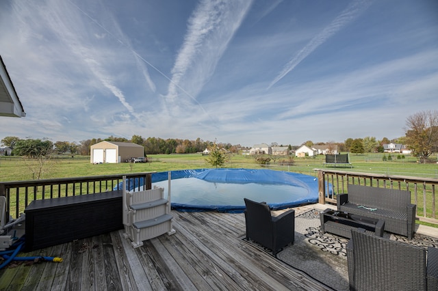 deck with a storage shed, a lawn, and a covered pool