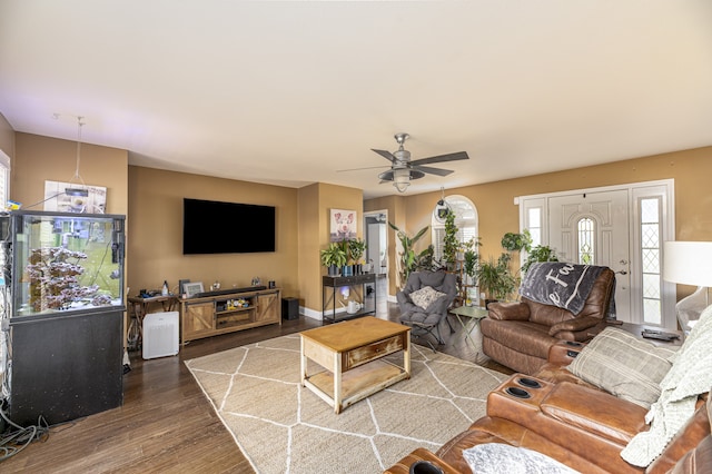 living room featuring dark wood-type flooring and ceiling fan